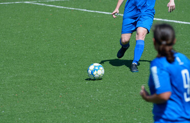 Girl football player attacking legs kicking soccer ball