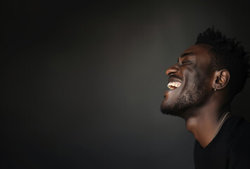 Joyful young man laughing in a dark background - 748011158