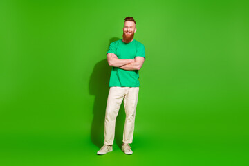 Full length photo of funky confident guy wear t-shirt smiling arms crossed empty space isolated green color background