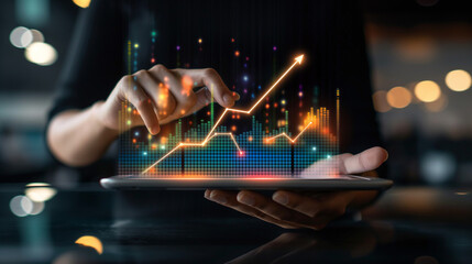 Businessman holding tablet and showing a growing virtual hologram of statistics, graph and chart with arrow up on dark background. Stock market. Business growth, planing and strategy concept. - obrazy, fototapety, plakaty
