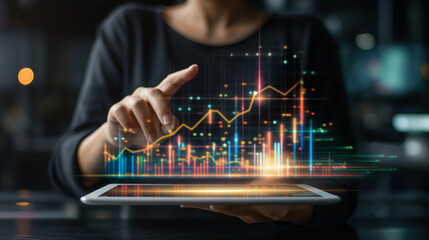Businessman holding tablet and showing a growing virtual hologram of statistics, graph and chart with arrow up on dark background. Stock market. Business growth, planing and strategy concept.