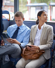 Business people, man and woman on bus for public transport, newspaper and smartphone for urban...