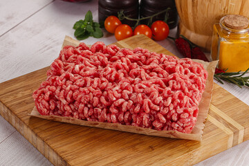 Raw minced beef meat over board