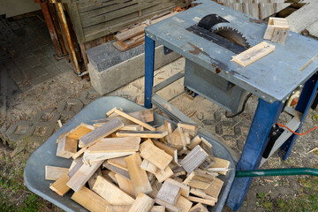 Circular saw with cut firewood in the background