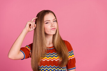Portrait of pensive young lady arm finger scratch head remember empty space isolated on pink color...