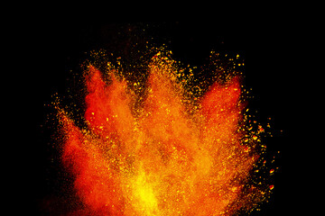 Abstract powder splatted background. Colorful powder explosion on black background. Colored cloud. Colorful dust explode. Freeze motion of orange color powder exploding 