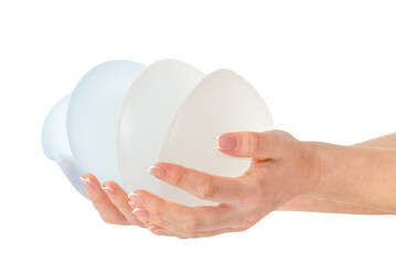 Variety of breast implants in hands on white background
