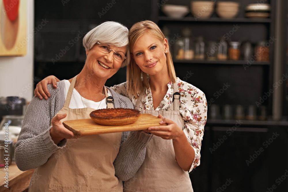 Poster Portrait, happy woman and elderly mother with pie in kitchen, cooking or smile of family showing homemade food together in house. Face, daughter or senior mom with dessert, pastry or help with baking