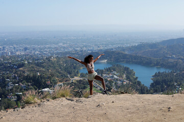 Carefree African American Woman Posing Happy at the Edge of the Mountain of Hollywood, Los Angeles...