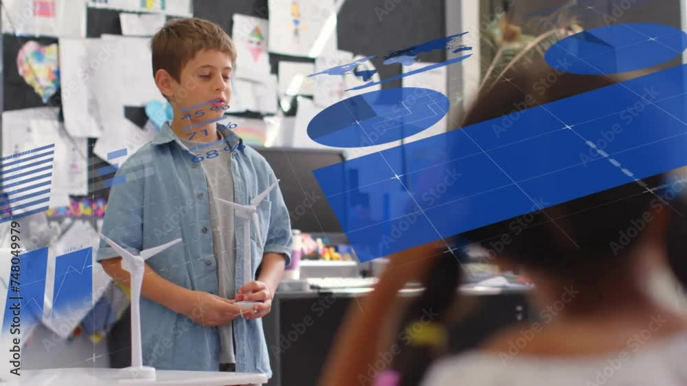 Wall mural Animation of charts and data processing over caucasian schoolboy with windmill in classroom