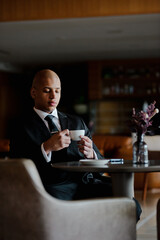 African american businessman holding coffee during break in business center