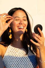 Happy South American Woman Putting Make up On  in the Afternoon