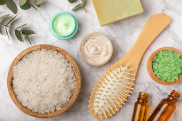 Beautiful spa composition on a wooden background with eucalyptus leaves. Beauty and fashion spa concept with body cream, scrub, mask, essential oil and sea salt.Cosmetic product. Copy space.