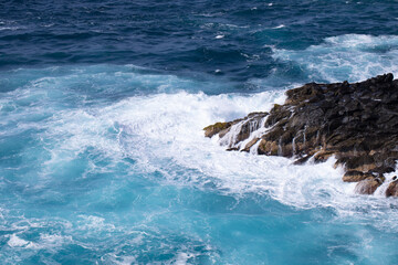 landscape of the coastline when the waves form an eddy in the water as they break against the rocky shore.