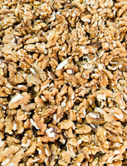 The walnut is a type of nut produced by trees in the genus Juglans. It is encased in a hard, wrinkled shell that is surrounded by a green husk when fresh, which turns brown and brittle as it ripens.