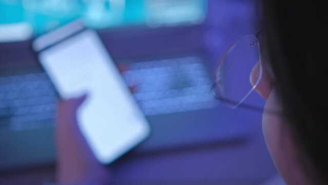 female student prepares homework using mobile phone laptop indoors slow motion. Casual woman searching information for project in smartphone 4K
