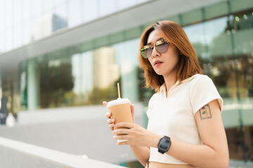 Business asian entrepreneur smart woman drink coffee on office building background