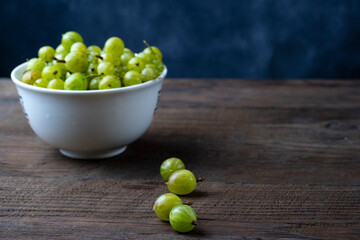 Ripe green gooseberries on a wooden table. Organic gooseberries.