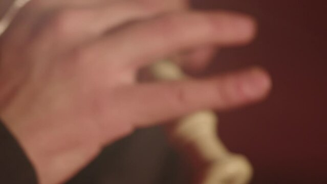 close-up of the hands of a male piper playing the pipe with his fingers.