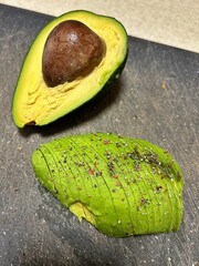 fresh avocado, avocado cut in half, green fruit, avocado sprinkled with salt and colored pepper