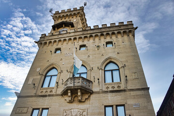 Fototapeta na wymiar The Government Palace of the Republic of San Marino with the flag of San Marino flying from the balcony in the central square of the city