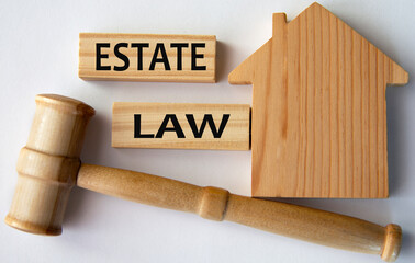 ESTATE LAW - words on a wooden block on the background of a house and a referee's gavel
