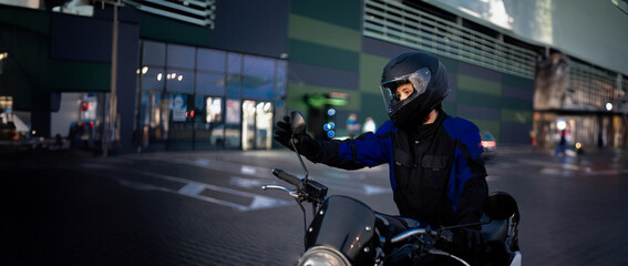 female motorcyclist close-up in a helmet in the evening on a motorcycle in the city.