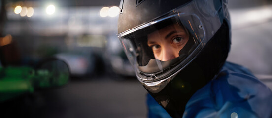 female motorcyclist close-up in a helmet in the evening on a motorcycle in the city. - obrazy, fototapety, plakaty