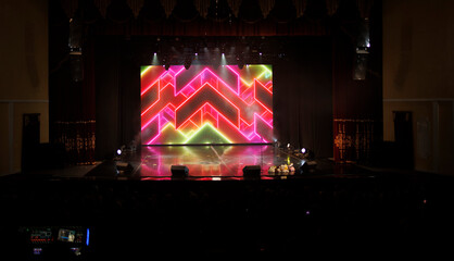 An empty stage of the theater, lit by spotlights and smoke before the performance