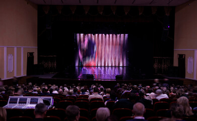 An empty stage of the theater, lit by spotlights and smoke before the performance
