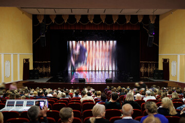 An empty stage of the theater, lit by spotlights and smoke before the performance