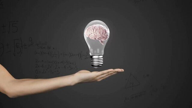 Animation of mathematical data processing over human brain in lightbulb over woman's hand