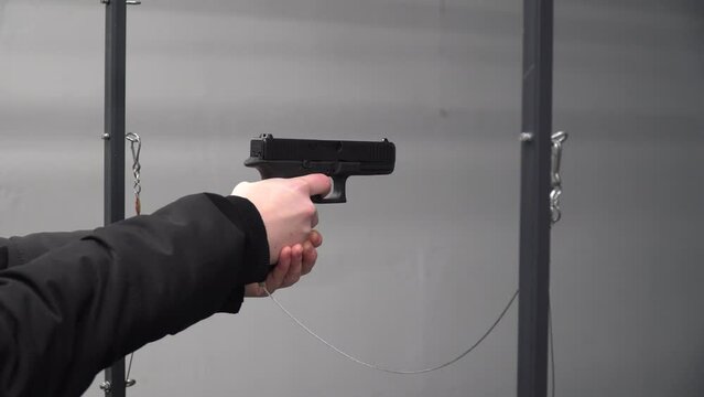 A girl fires a gun. Shooting range. Shooting from a gun. Shooting from a machine gun. Training in shooting. Guns.