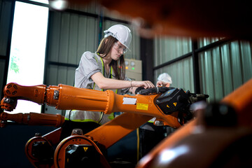 Fototapeta premium Factory engineers inspecting on machine with smart tablet. Worker works at heavy machine robot arm. The welding machine with a remote system in an industrial factory. Artificial intelligence concept.