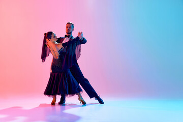 Elegant, passionate young couple, man and woman dancing ballroom in back stage costumes against...