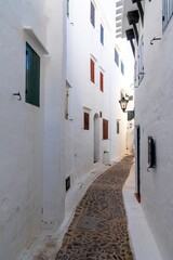 narrow alley leading through a maze of whitewashed buildings in the village center of Binibeca Vell