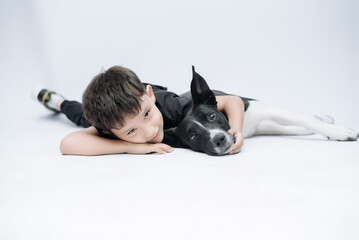 Child smiling at the camera while hugging his dog