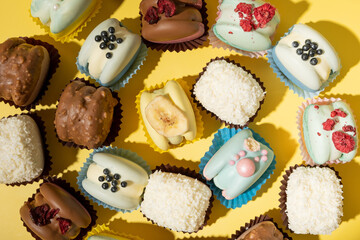 Set of different macaroons on yellow background top view, flat lay
