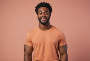 Fototapeta premium A fit man in a peach t-shirt smiles warmly. His athletic build and relaxed demeanor portray health and confidence.