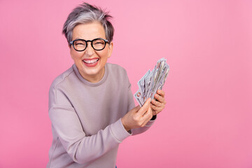 Photo of positive attractive retired woman hold banknotes casino lottery betting gambling win prize...
