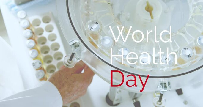 Animation of world health day text over caucasian male scientist collecting test tubes