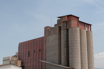 A truck seen parked in front of the grain silos