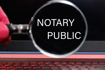 NOTARY PUBLIC is written through a magnifying glass on a black laptop screen