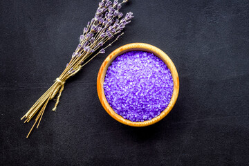 purple spa salt for aroma therapy with lavender flower fragrance on dark background top view...