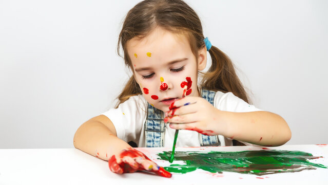 children's creativity. Portrait Cute caucasian child girl with face and hands painted at home
