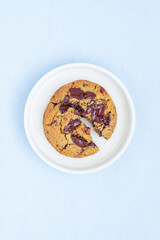 A piece of homemade chocolate chip cookie on ceramic plate.