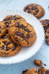 A piece of homemade chocolate chip cookie on ceramic plate.
