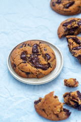 A piece of homemade chocolate chip cookie on ceramic plate.