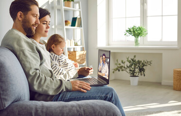 Young family having online telemedicine consultation on a laptop with their paediatrician doctor...