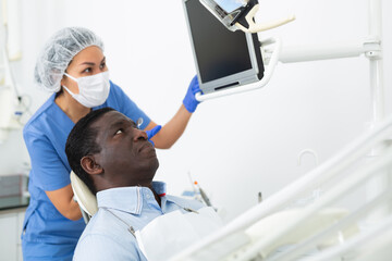 Doctor dentist shows the patient the result of a dental x-ray